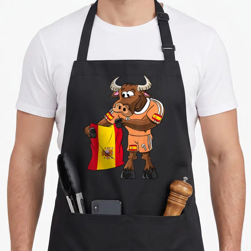 Tablier de cuisine noir avec un taureau fan en maillot orange tenant une cape rouge et jaune.