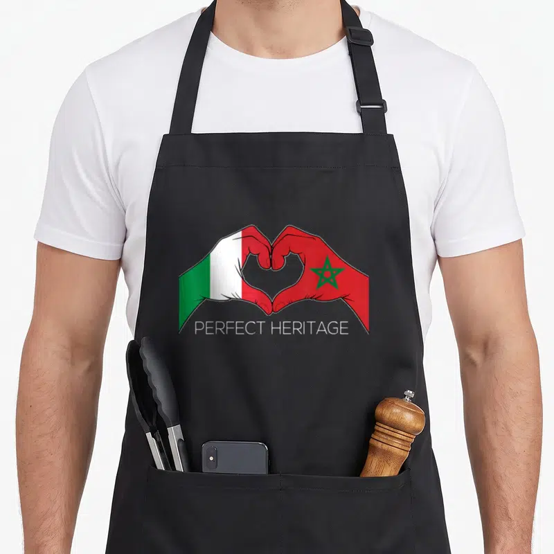 Tablier de cuisine noir avec deux mains formant un cœur aux drapeaux italien et marocain et le texte Perfect Heritage en blanc.