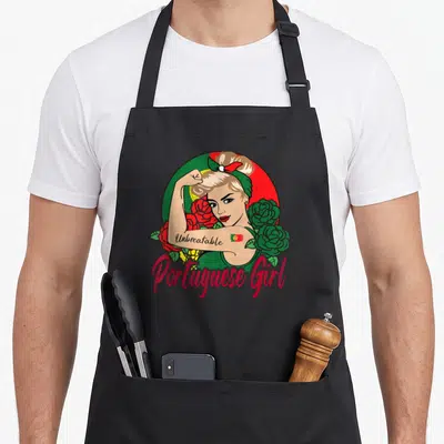 Tablier de cuisine noir avec une femme blonde au poing levé, des roses et l'inscription Portuguese Girl en rose.