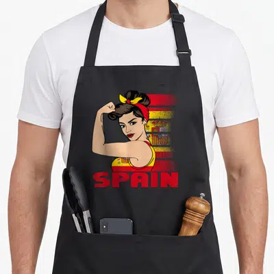 Tablier de cuisine noir avec illustration d'une femme musclée aux couleurs de l'Espagne et le texte SPAIN en rouge.