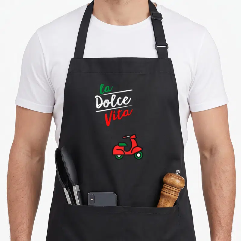 Tablier de cuisine noir avec inscription La Dolce Vita et illustration de scooter rouge à la selle verte.