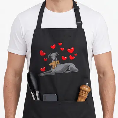 Tablier de cuisine noir avec illustration d'un lévrier italien tenant une peluche et des cœurs rouges flotants.
