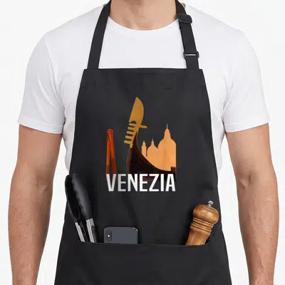 Tablier de cuisine noir avec une gondole stylisée, des mottes orange et le texte Venezia en blanc.