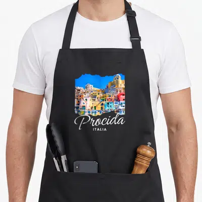 Tablier de cuisine noir avec illustration des maisons colorées de Procida et l'inscription Italia en bas.