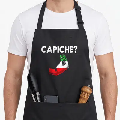 Tablier de cuisine noir avec le texte Capiche et un poignet aux couleurs du drapeau italien.