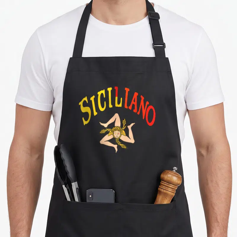 Tablier de cuisine noir avec l'inscription Siciliano et une illustration colorée de la Trinacria aux épis de wheat dorés.