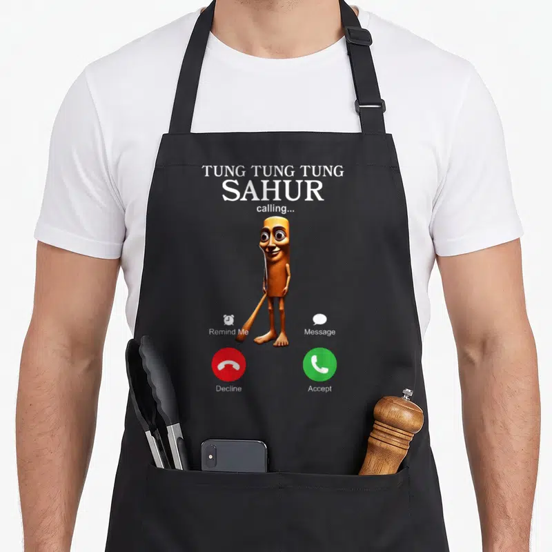 Tablier de cuisine noir avec personnage cylindrique tenant une batte et texte blanc sur fond gris imitant une interface de téléphone portable.