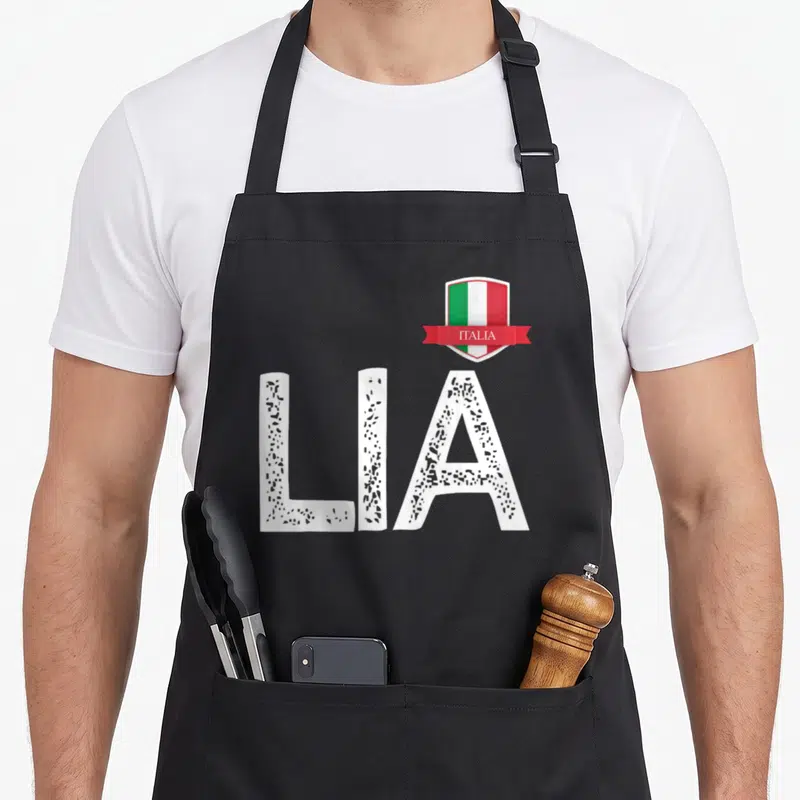 Tablier de cuisine noir avec les lettres LIA et un blason affichant le drapeau italien ainsi que l'inscription ITALIA sur une banderole.