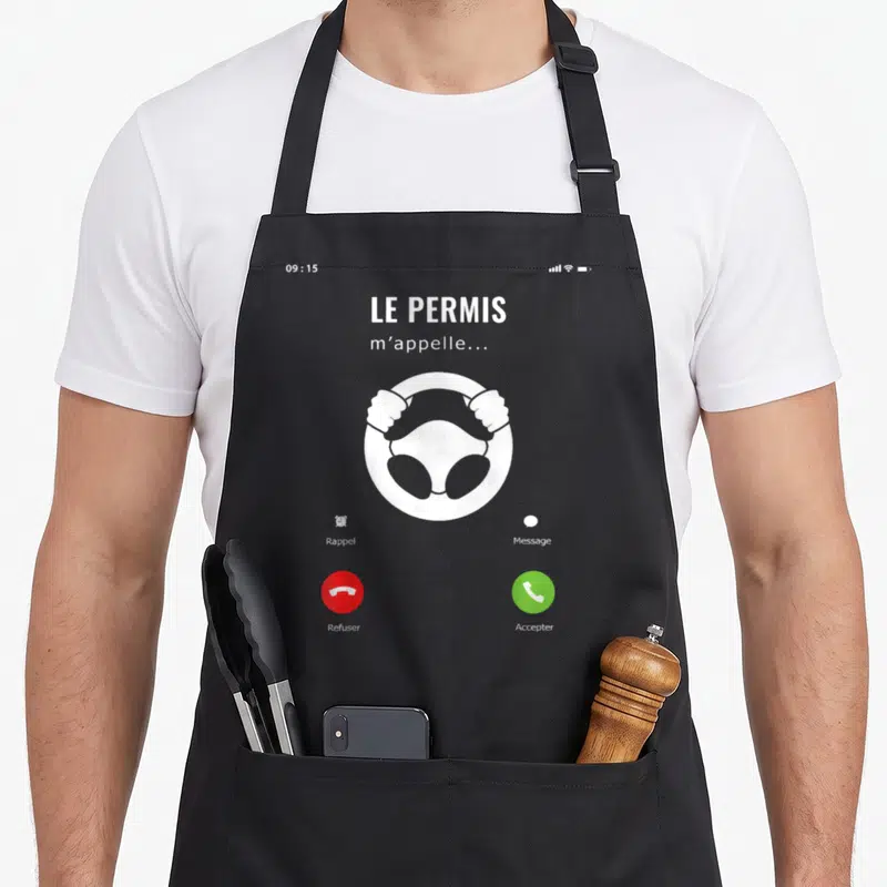 Tablier de cuisine noir avec une illustration blanche d'un écran de téléphone indiquant que le permis m'appelle, incluant un volant et des boutons d'accord ou de refus.