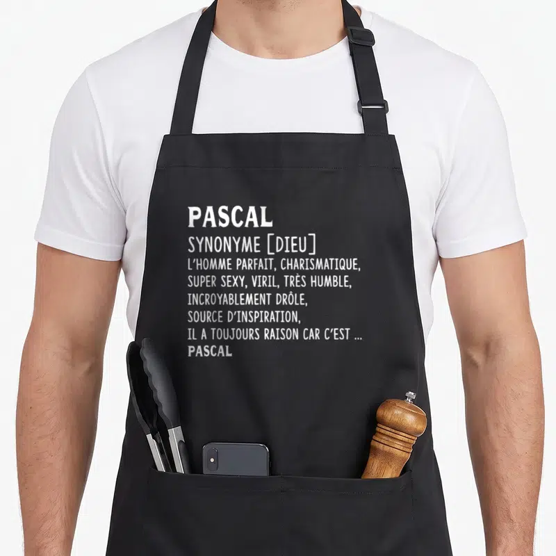 Tablier de cuisine noir avec le prénom Pascal et sa définition humoristique en lettres blanches capitales.