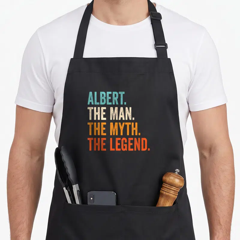 Tablier de cuisine noir avec inscription ALBERT THE MAN THE MYTH THE LEGEND en lettres colorées.