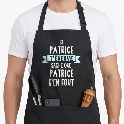 Tablier de cuisine noir avec le texte blanc et bleu Si Patrice t'énerve sache que Patrice s'en fout imprimé au centre.