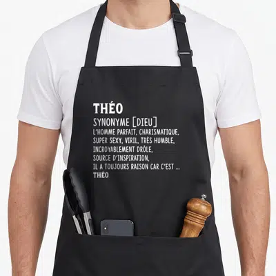 Tablier de cuisine noir avec le prénom Théo et sa définition humoristique en lettres blanches.