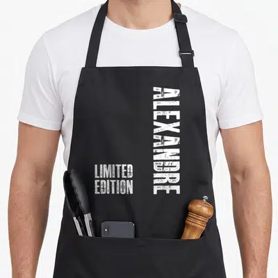 Tablier de cuisine noir avec le prénom Alexandre imprimé verticalement en blanc et la mention Limited Edition en bas à gauche.