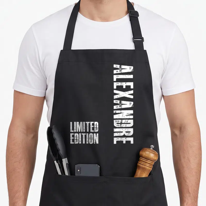 Tablier de cuisine noir avec le prénom Alexandre imprimé verticalement en blanc et la mention Limited Edition en bas à gauche.