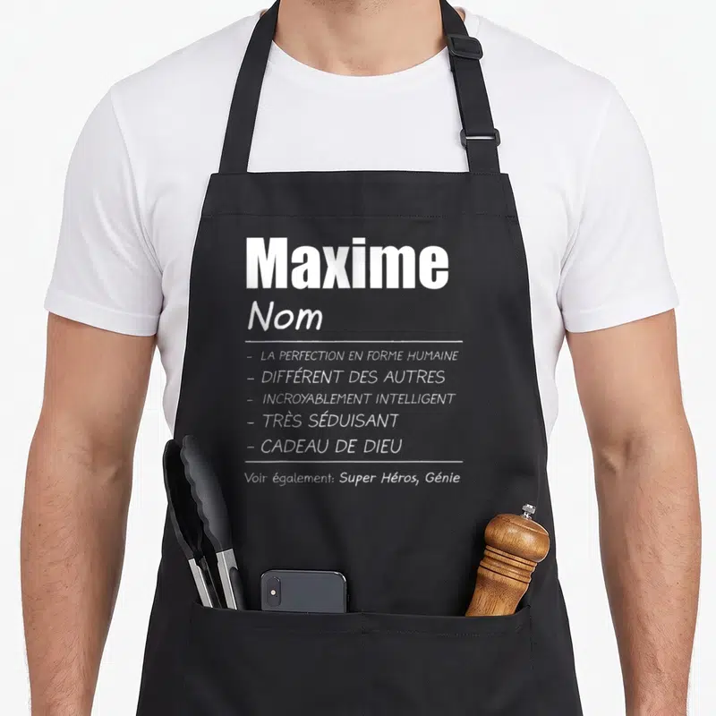 Tablier de cuisine noir avec le nom Maxime et la liste des qualités La perfection en forme humaine et Cadeau de Dieu.