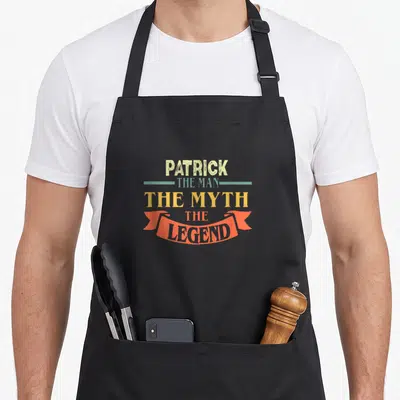 Tablier de cuisine noir avec le texte Patrick The Man The Myth The Legend en typographie vintage multicolore.