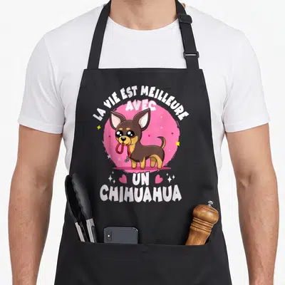Tablier de cuisine noir avec illustration colorée d'un chihuahua marron et d'un message en français sur fond rose vif.