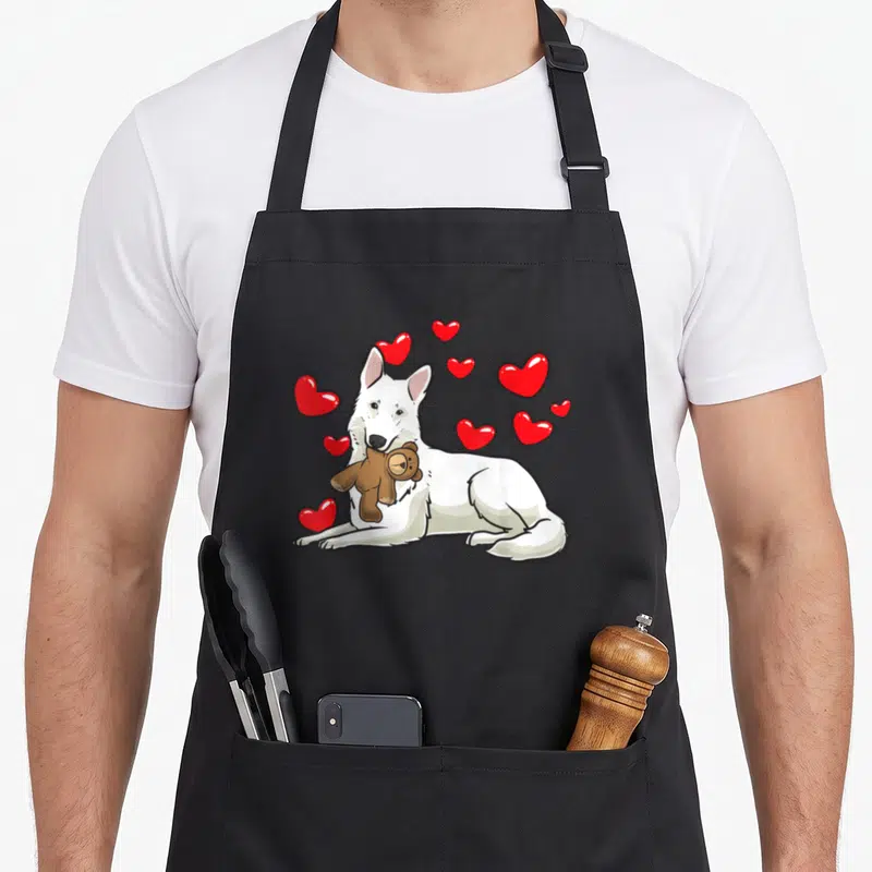Tablier de cuisine noir avec illustration d'un chien blanc tenant un ours en peluche et des cœurs rouges flottants.