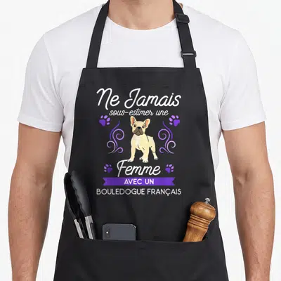 Tablier de cuisine noir avec illustration d'un Bouledogue Français, pattes violettes et texte blanc sur fond uni.