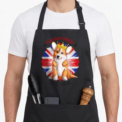 Tablier de cuisine noir avec un Corgi couronné sur fond Union Jack et texte Platinum Jubilee 1952-2022