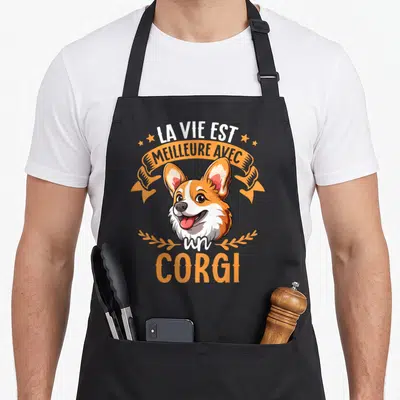 Tablier de cuisine noir avec un corgi souriant et l'inscription La Vie Est Meilleure Avec Un Corgi en orange et blanc.