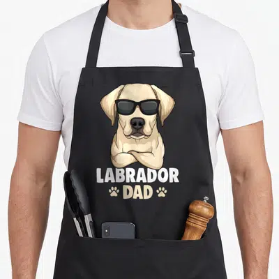 Tablier de cuisine noir avec illustration d'un chien Labrador portant des lunettes noires et le texte Labrador Dad