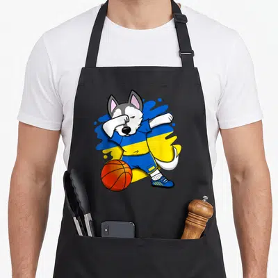 Tablier de cuisine noir avec un husky en maillot ukrainien effectuant un dab près d'un ballon de basket-ball orange.
