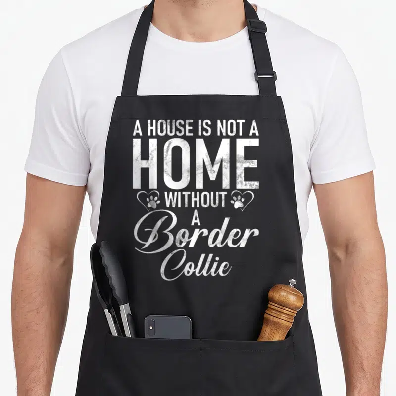 Tablier de cuisine noir avec inscription blanche A HOUSE IS NOT A HOME WITHOUT A Border Collie et deux empreintes dans des cœurs.