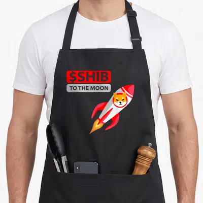 Tablier de cuisine noir avec un Shiba Inu dans une fusée rouge et blanche et le texte $SHIB TO THE MOON.