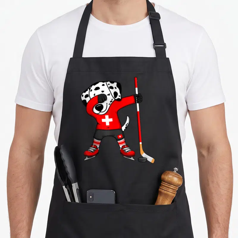Tablier de cuisine noir avec un Dalmatien en maillot rouge suisse faisant un dab avec une crosse de hockey.