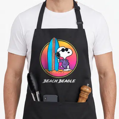 Tablier de cuisine noir avec Snoopy en beach beagle surf, planche bleue et texte Beach Beagle en bas.