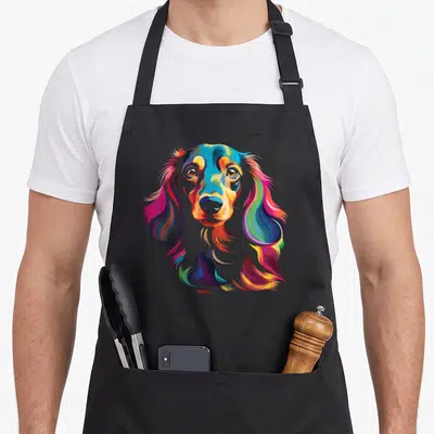 Tablier de cuisine noir avec portrait stylisé d'un teckel à poil long multicolore aux tons vifs.