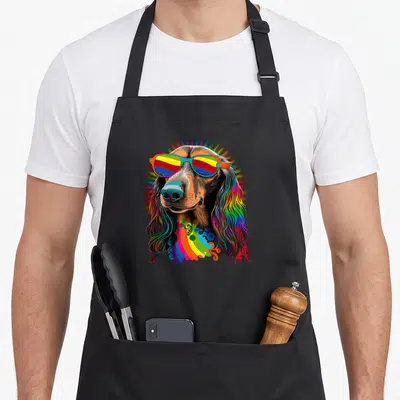 Tablier de cuisine noir avec illustration d'un teckel hippie aux cheveux multicolores et lunettes de soleil rayées.