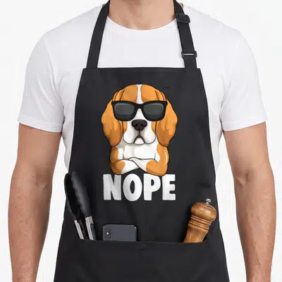 Tablier de cuisine noir avec illustration d'un beagle aux lunettes noires et pattes croisées au-dessus du mot Nope en blanc.