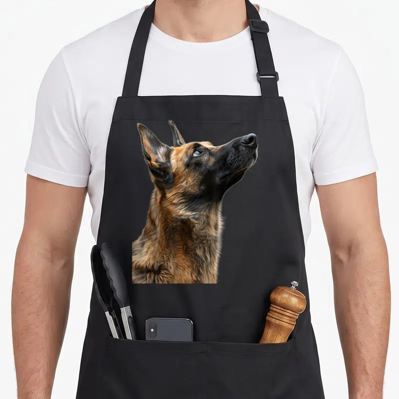 Tablier de cuisine noir avec un portrait réaliste et détaillé d'un Malinois belge regardant vers le haut.