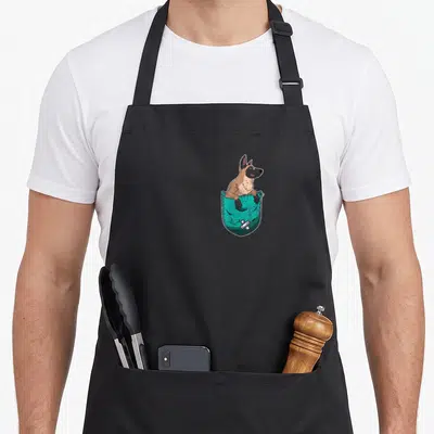 Tablier de cuisine noir avec illustration d'un Malinois de poche sortant d'une poche turquoise.