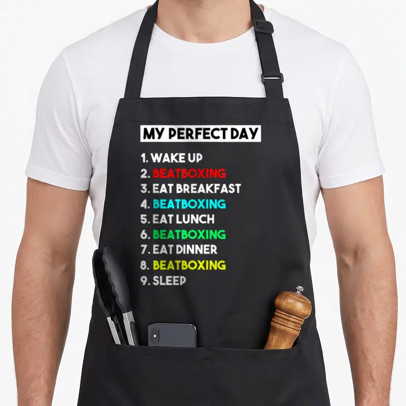Tablier de cuisine noir avec une liste numerique en anglais et des mots beatboxing en couleurs vives sur fond gris.