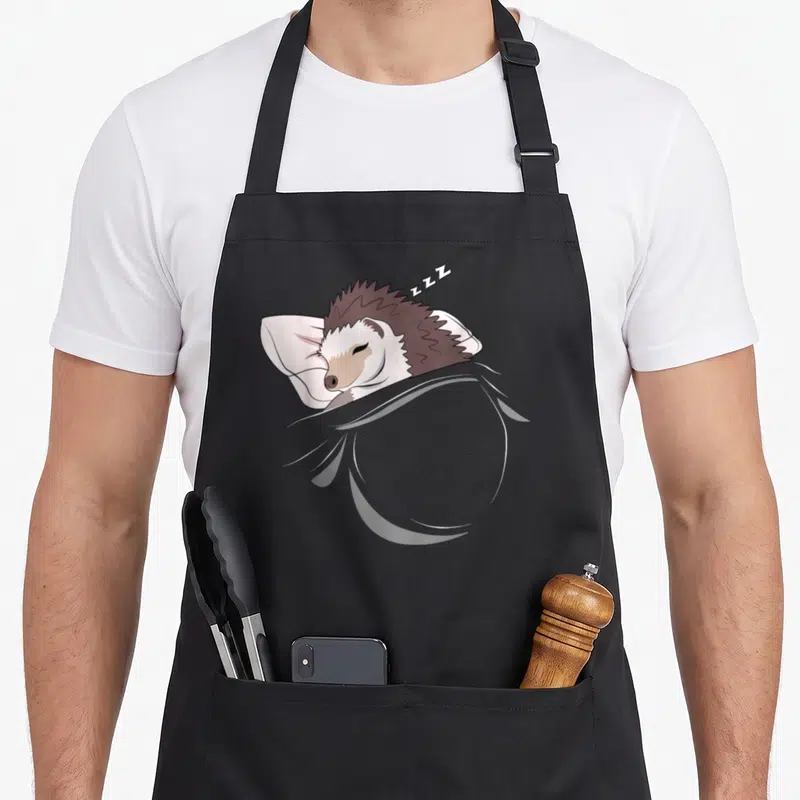 Tablier de cuisine noir avec illustration d'un hérisson dormant sur un oreiller et des ZZZ au-dessus.