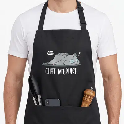 Tablier de cuisine noir avec un chat gris allongé et le texte CHAT M'ÉPUISE en blanc.