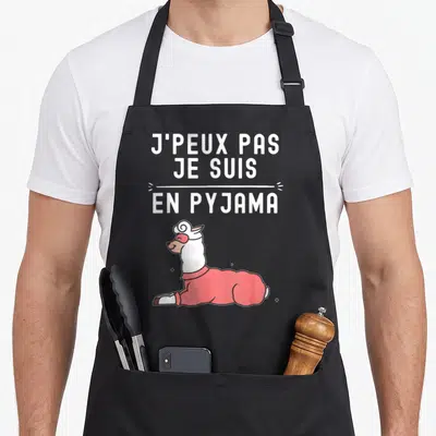 Tablier de cuisine noir avec un lama en pyjama rose et l'inscription blanche J'peux pas je suis en pyjama