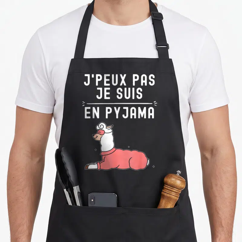 Tablier de cuisine noir avec un lama en pyjama rose et l'inscription blanche J'peux pas je suis en pyjama