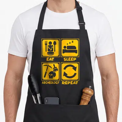 Tablier de cuisine noir avec quatre icônes jaunes illustrant manger dormir archéologie et répéter dans un style graphique plat.