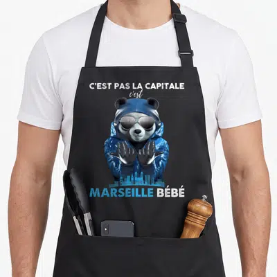 Tablier de cuisine noir avec un panda en veste bleue, lunettes noires et skyline bleu de Marseille Bébé imprimé en bas.