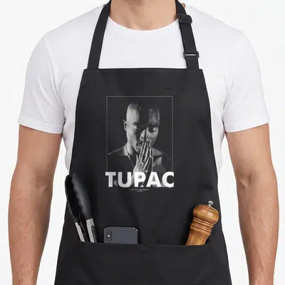 Tablier de cuisine noir avec portrait monochrome de Tupac Shakur et le mot TUPAC en blanc.