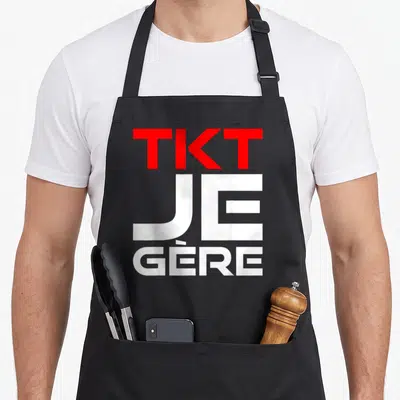 Tablier de cuisine noir avec inscription TKT Je Gère en lettres rouges et blanches stylisées.