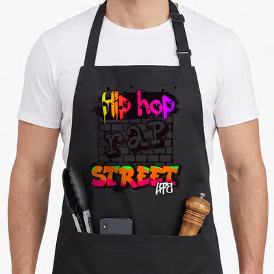 Tablier de cuisine noir avec un motif graffiti coloré représentant des murs de briques et du texte stylisé Hip Hop Rap Street Life.