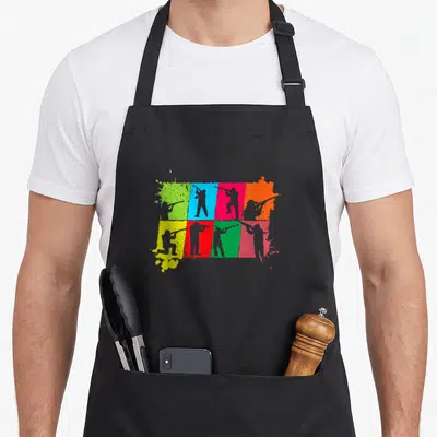 Tablier de cuisine noir avec silhouettes tirant au fusil sur carreaux colorés style pop art.
