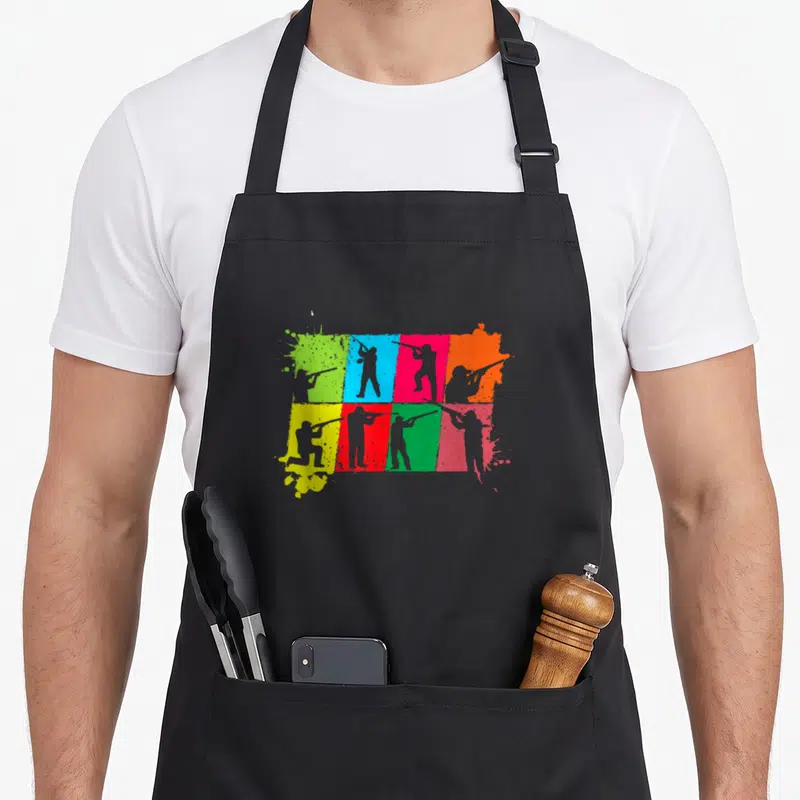 Tablier de cuisine noir avec silhouettes tirant au fusil sur carreaux colorés style pop art.
