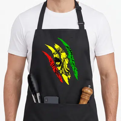 Tablier de cuisine noir avec illustration du Lion of Judah traversée par des griffes rouges jaunes et vertes.